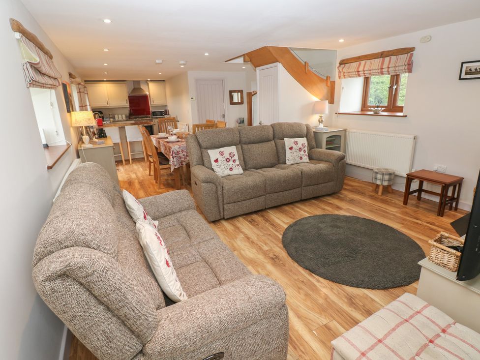A living room with seating and a dining area at The Gallops in Barry