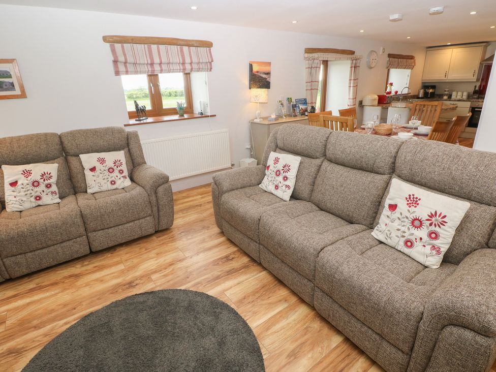 A living room with sofas and dining area at The Gallops in Barry