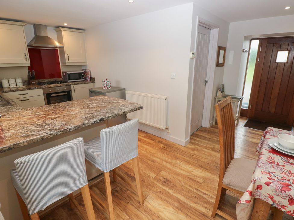 A kitchen with stools and a table at The Gallops in Barry