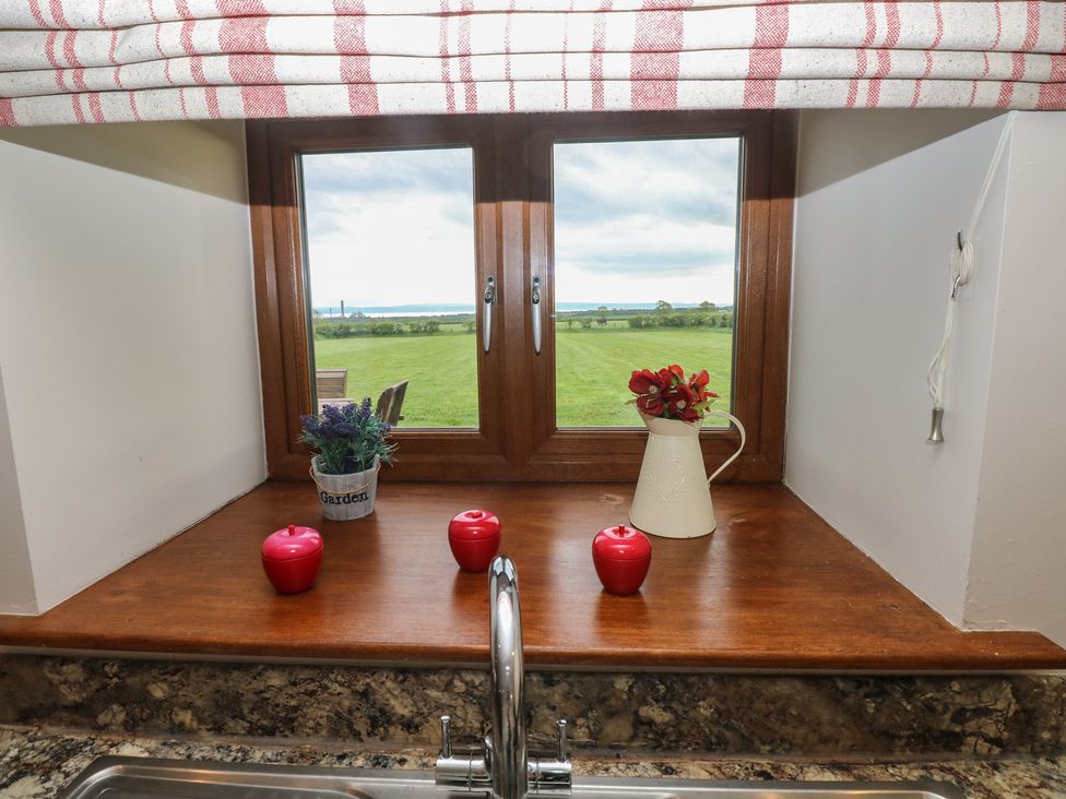 A kitchen window with plants and candles at The Gallops in Barry