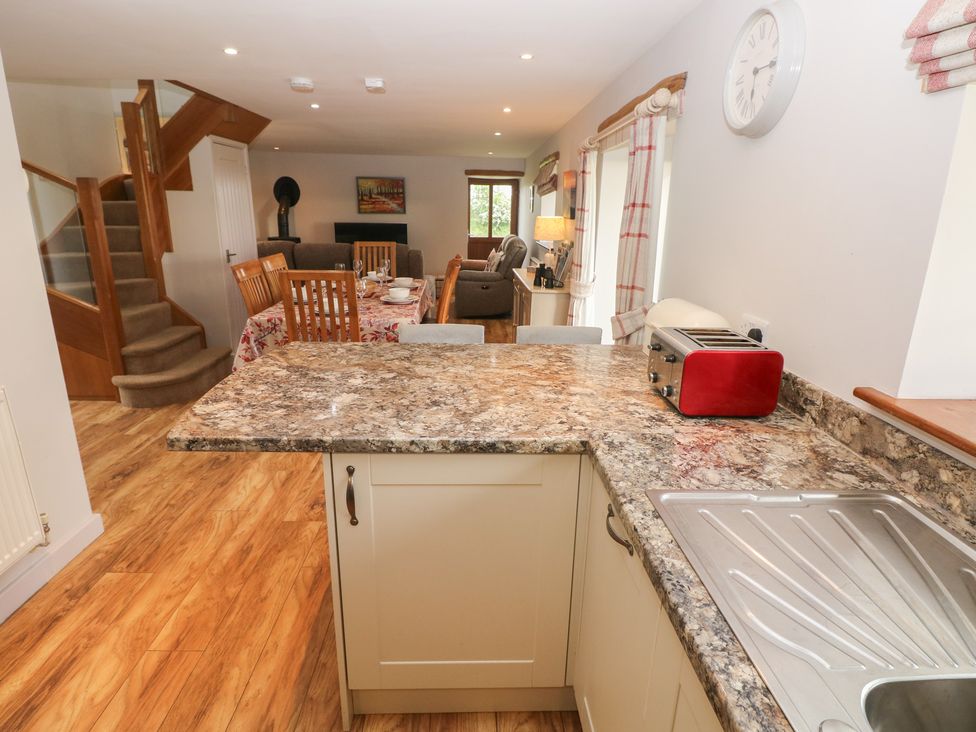 A kitchen with a granite countertop and dining area at The Gallops in Barry