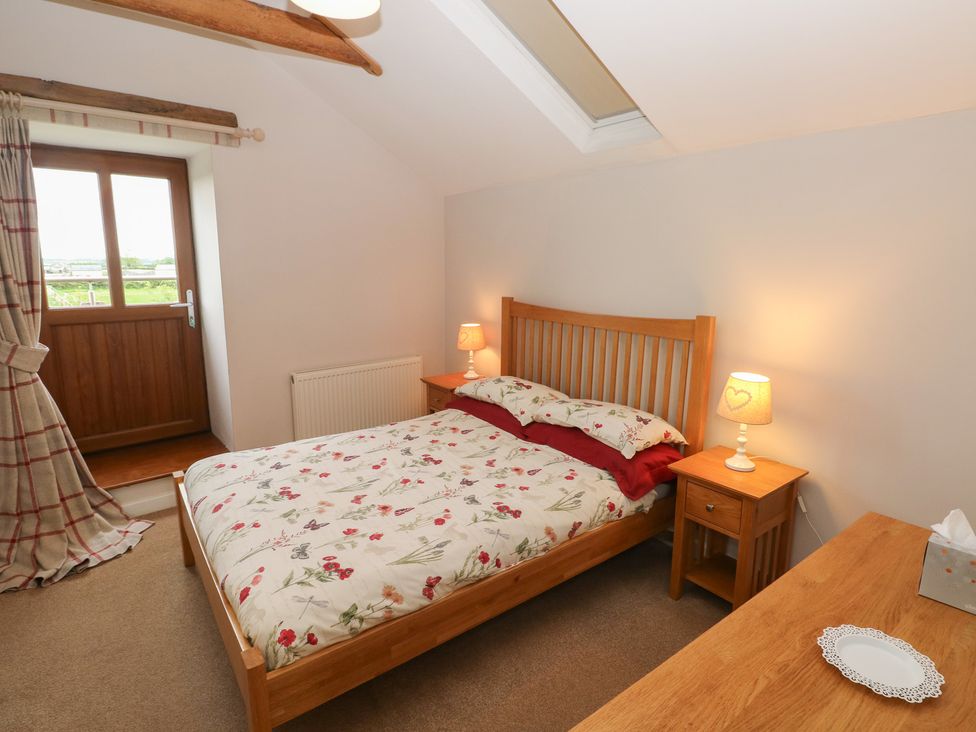 A bedroom with a bed and bedside table at The Gallops in Barry
