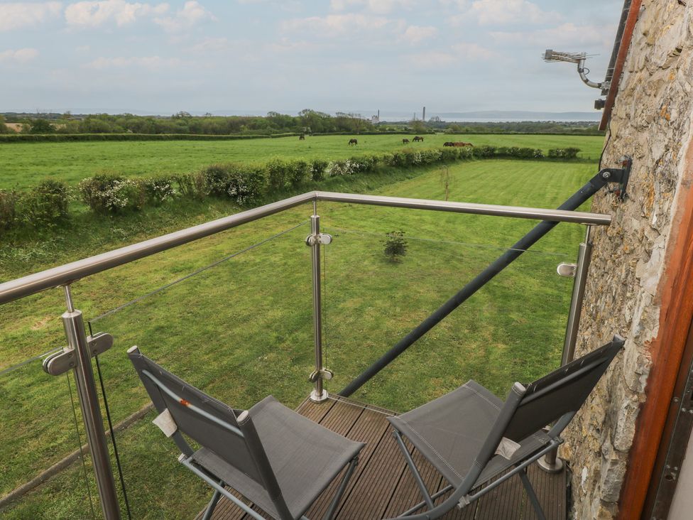 A balcony with chairs overlooking a grassy area at The Gallops in Barry
