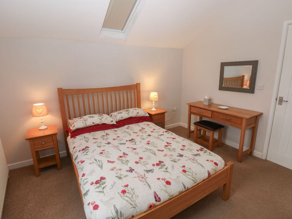 A bedroom with a bed and nightstand at The Gallops in Barry