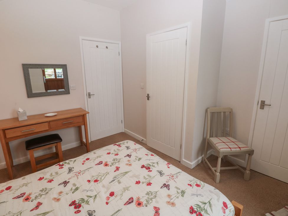A bedroom with a bed and a desk at The Gallops in Barry