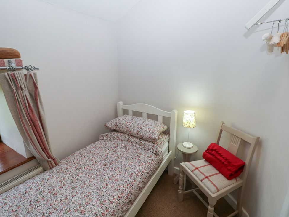 A bedroom with a single bed and lamp at The Gallops in Barry