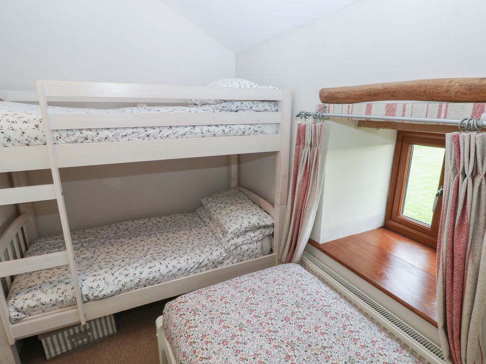 A bedroom with a bunk bed and single bed at The Gallops in Barry