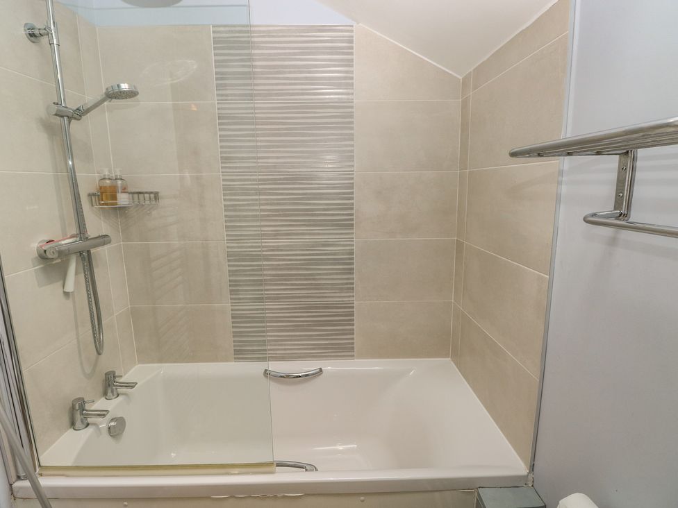 A bathroom with a shower over a bathtub at The Gallops in Barry
