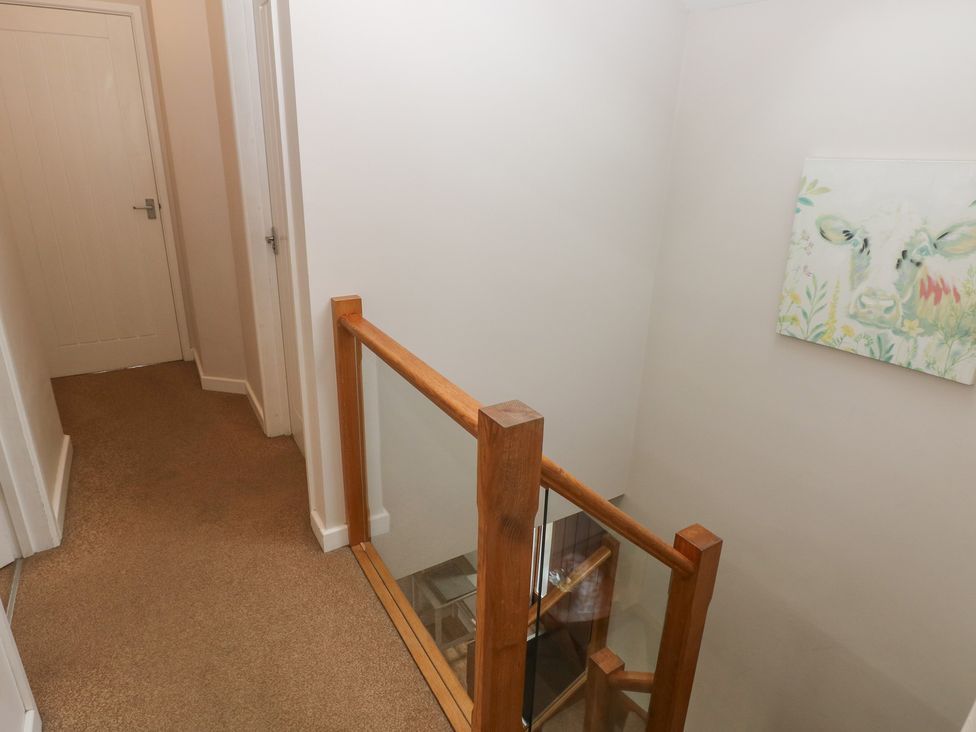 A hallway with a staircase and doors at The Gallops in Barry