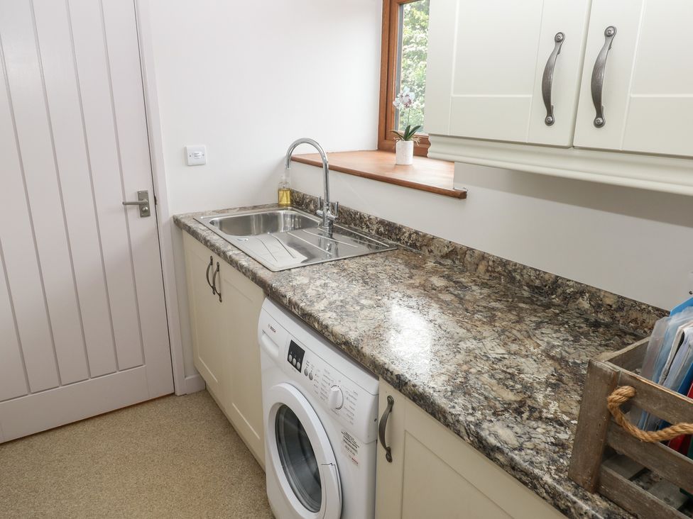 A laundry room with a washing machine and kitchen sink at The Gallops in Barry