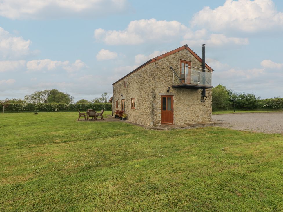 A house with grass and outdoor furniture at The Gallops in Barry