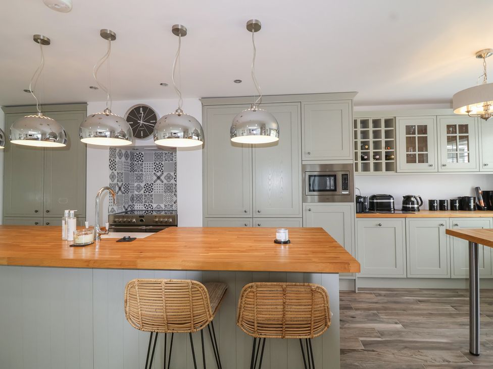 A kitchen with bar stools and kitchen island at Villina in Somerton