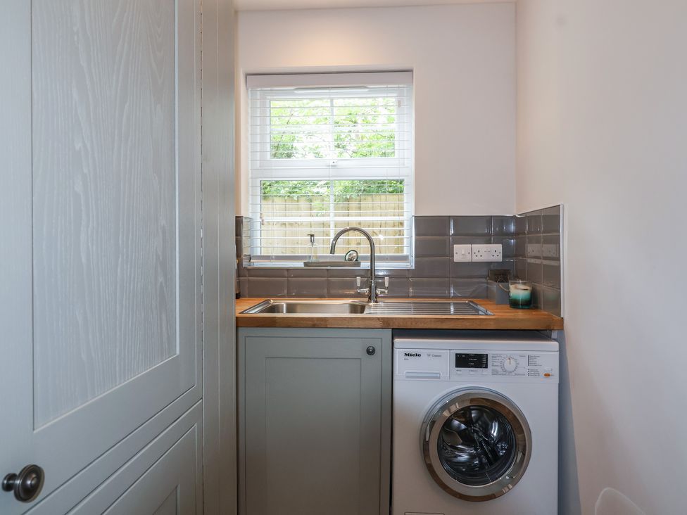 A laundry room with a washing machine and sink at Villina in Somerton