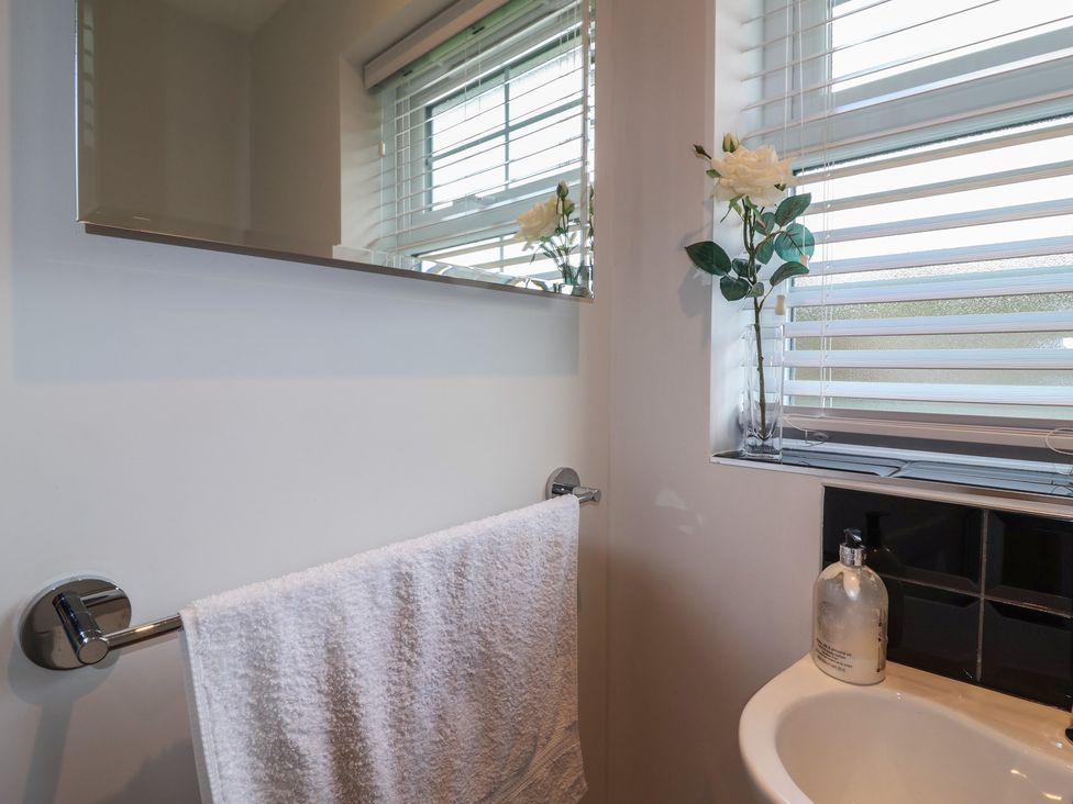 A bathroom with a mirror and a towel hanging at Villina Somerton