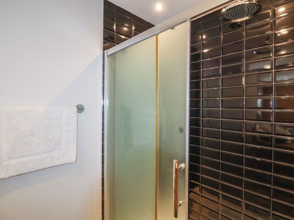 A shower with a glass door and towel rack at Villina in Somerton
