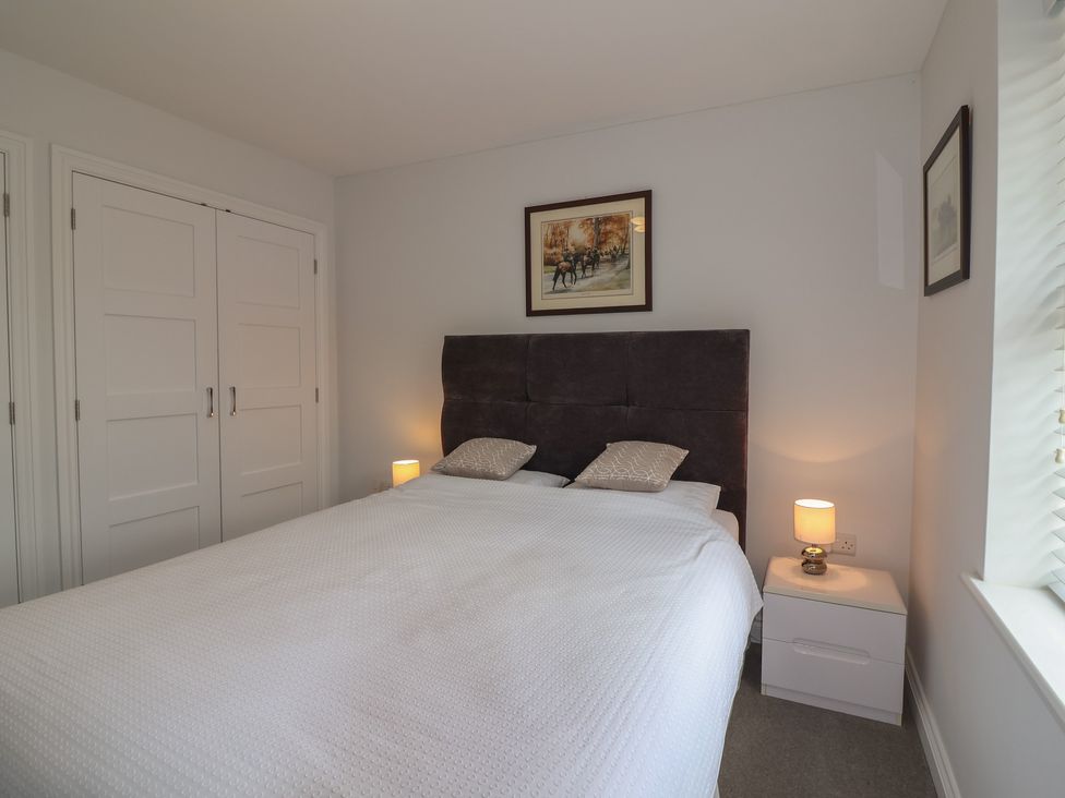 A bedroom with a bed, nightstand, lamp, and painting at Villina in Somerton
