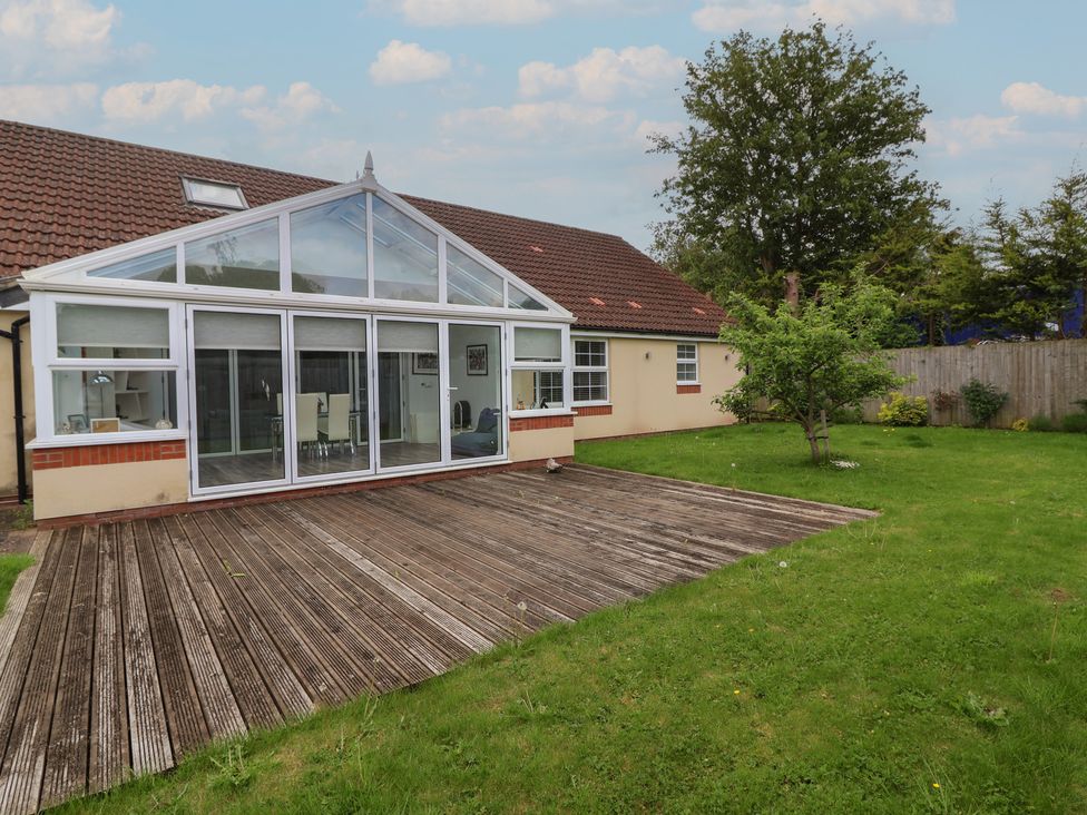 A conservatory with decking and garden at Villina in Somerton