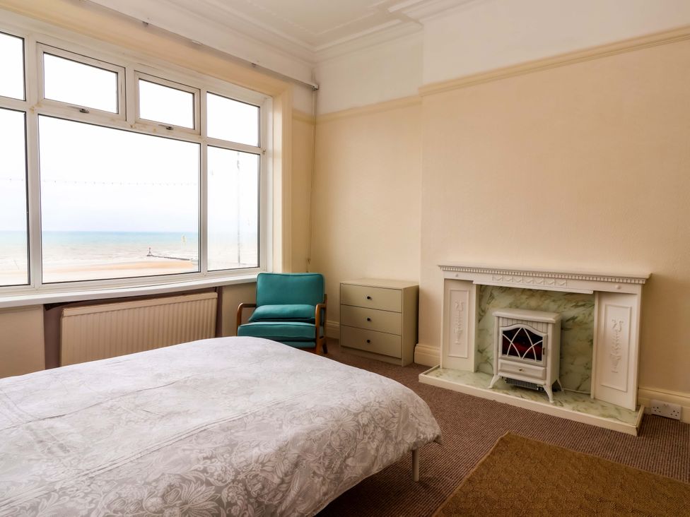 A bedroom with a bed and a window overlooking the sea at 72 South Marine Drive in Bridlington