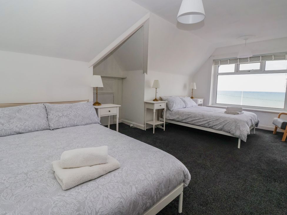 A bedroom with two beds and a window overlooking the sea at Sunrise Lodge in Bridlington