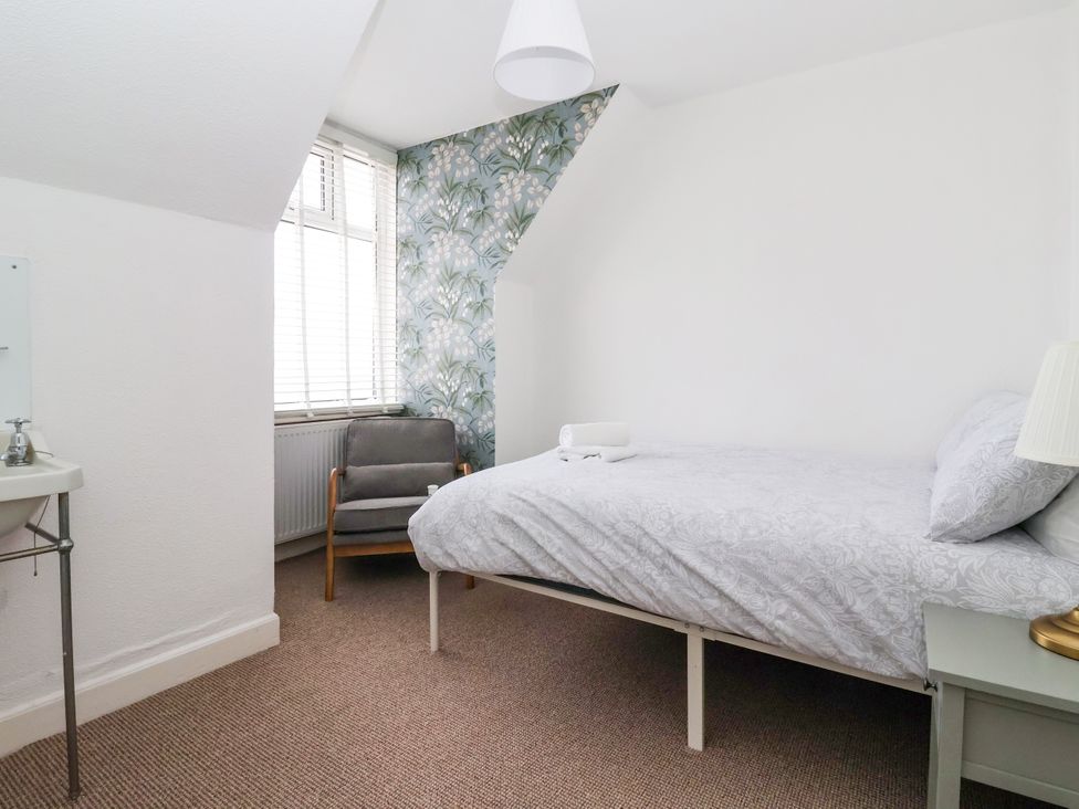 A bedroom with a bed and armchair at Sunrise Lodge in Bridlington