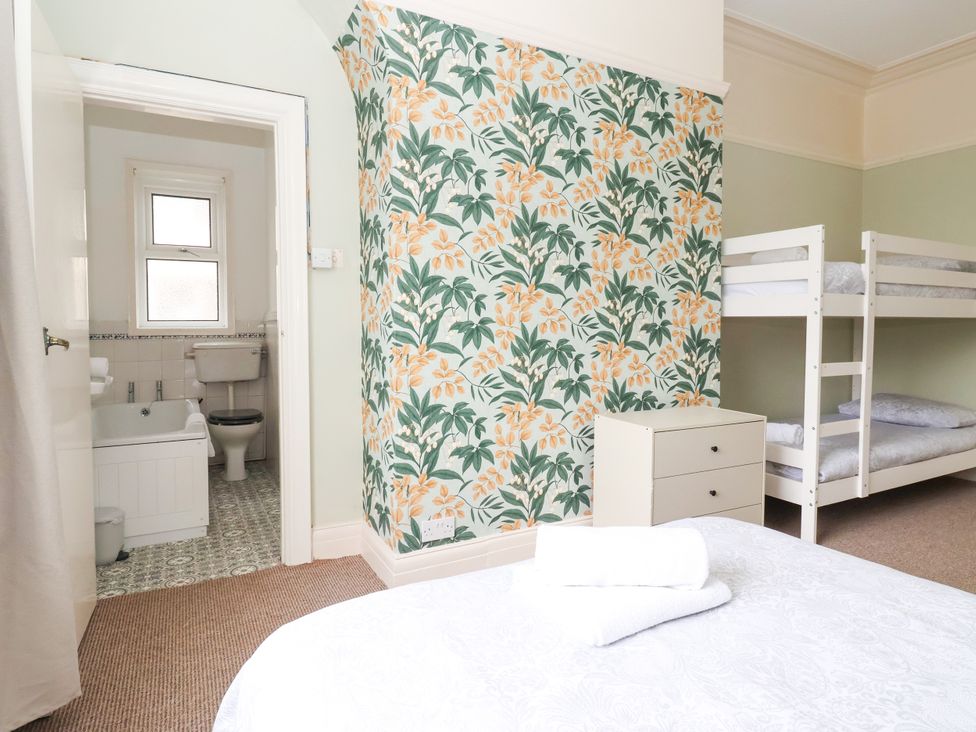 A bedroom with bunk beds and a bathroom doorway at Sunrise Lodge in Bridlington