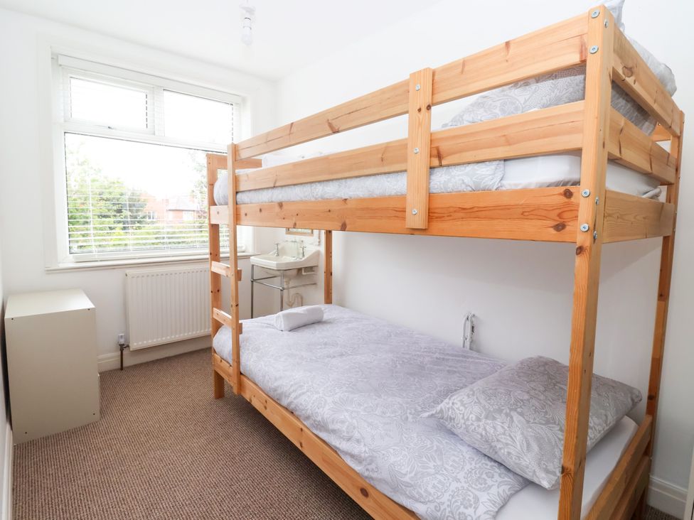 A bedroom with a bunk bed and side table at Sunrise Lodge in Bridlington