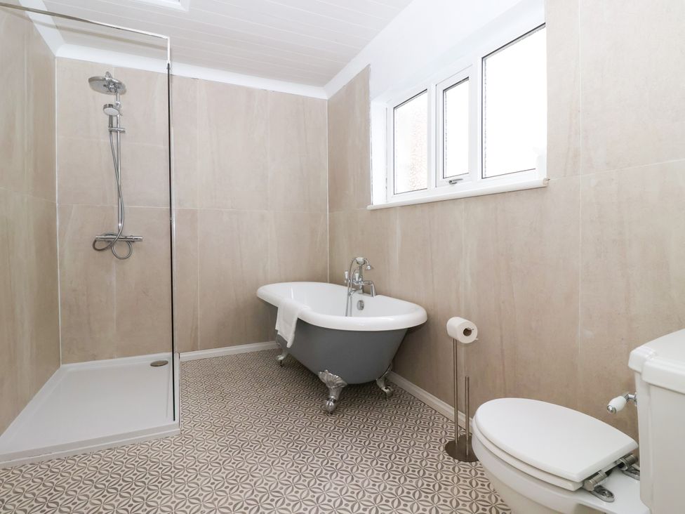 A bathroom with shower, bathtub, toilet, and sink at Sunrise Lodge in Bridlington