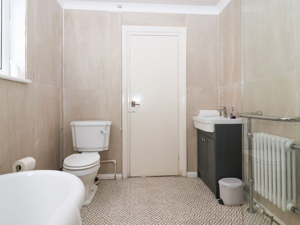 A bathroom with a toilet, sink, and bathtub at Sunrise Lodge in Bridlington