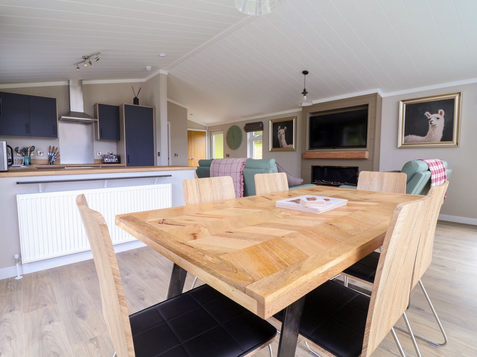 A kitchen with a dining table and chairs at Beach Lodge in Lloc