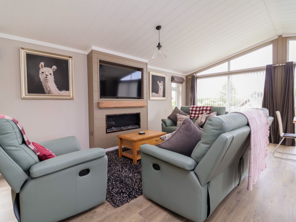 A living room with a sofa and a television at Beach Lodge in Lloc
