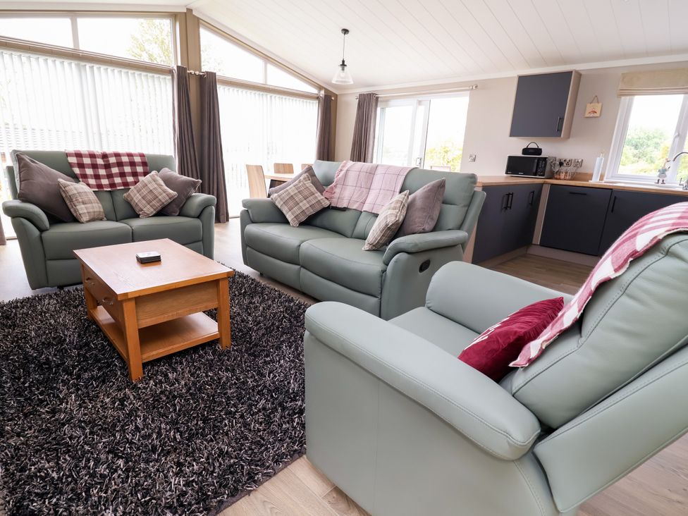 A living room with sofas and a coffee table at Beach Lodge in Lloc