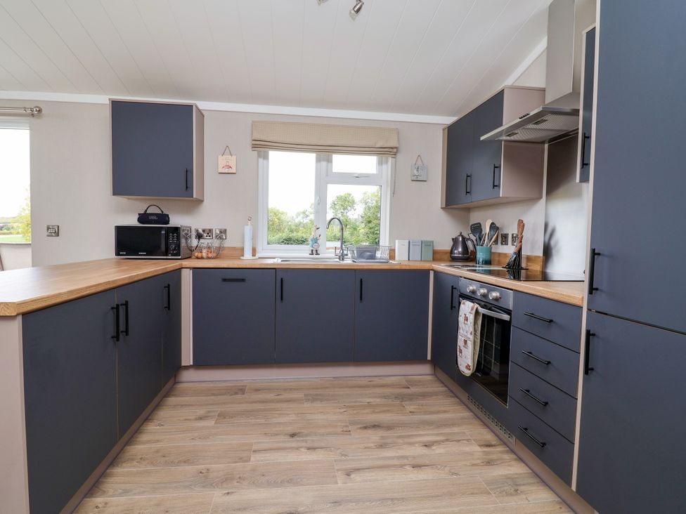 A kitchen with modern cabinets and appliances at Beach Lodge in Lloc