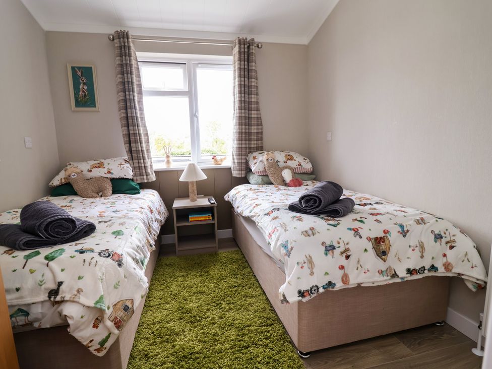 A bedroom with two beds and a lamp at Beach Lodge in Lloc