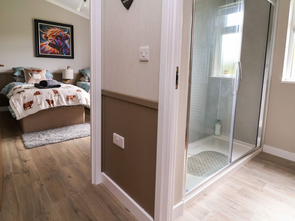 A bedroom featuring a bed and a shower at Beach Lodge in Lloc