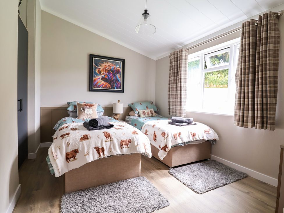 A bedroom with two beds and a painting at Beach Lodge in Lloc