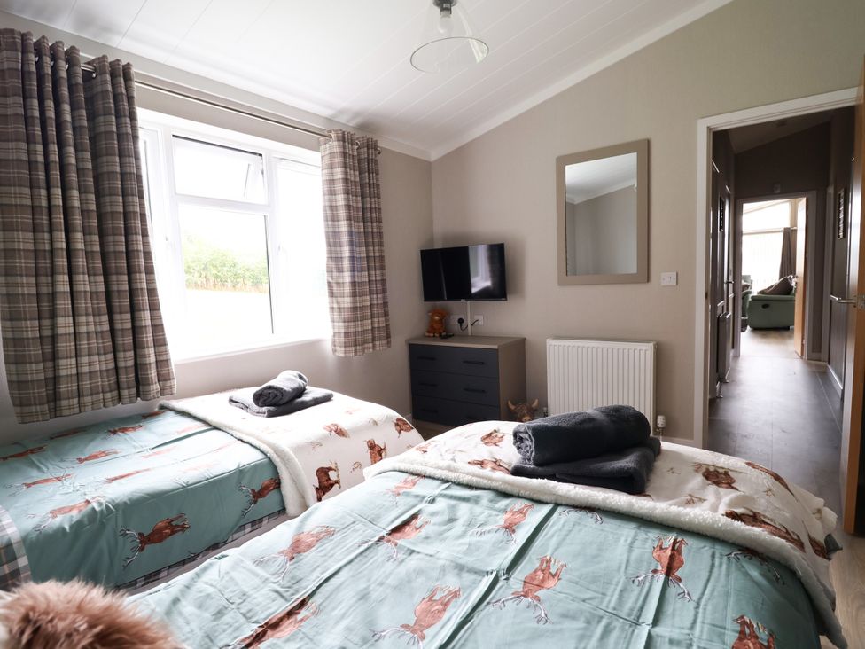 A bedroom with two beds and a television at Beach Lodge in Lloc