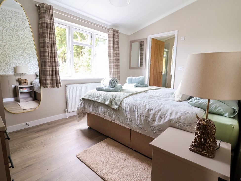 A bedroom with a bed and a lamp at Beach Lodge in Lloc