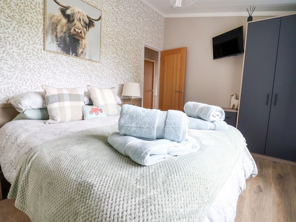 A bedroom with a bed and towels on it at Beach Lodge in Lloc