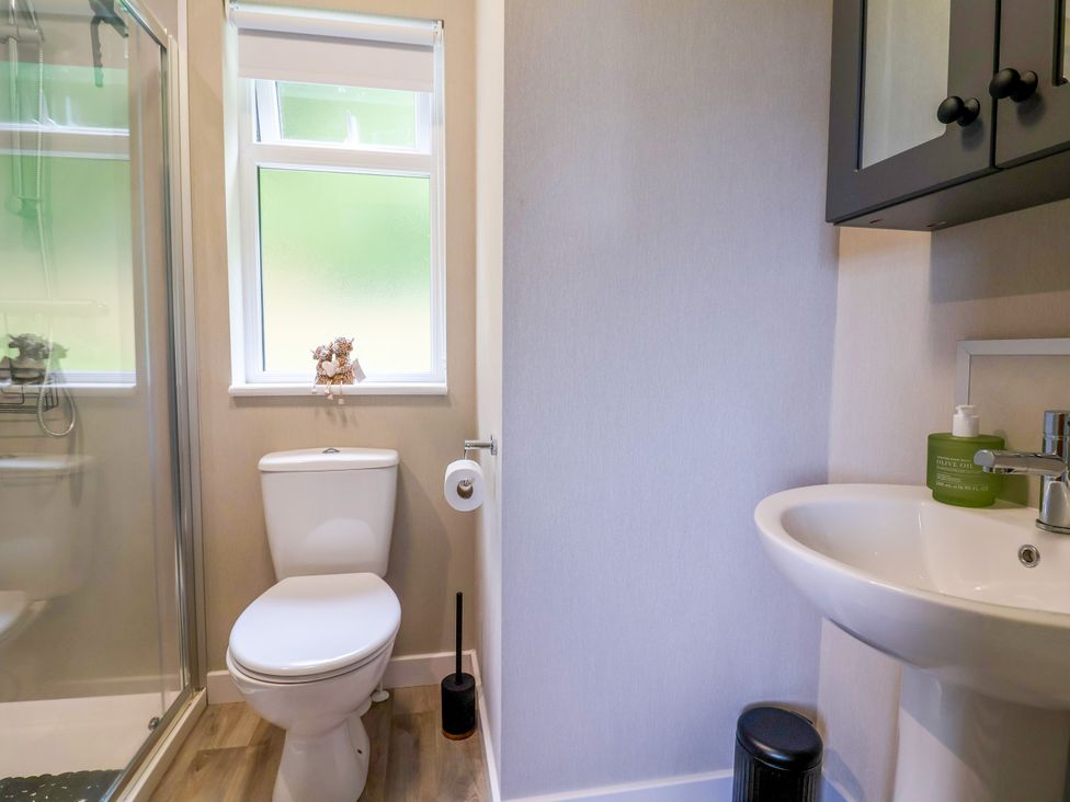 A bathroom with a toilet and shower at Beach Lodge in Lloc