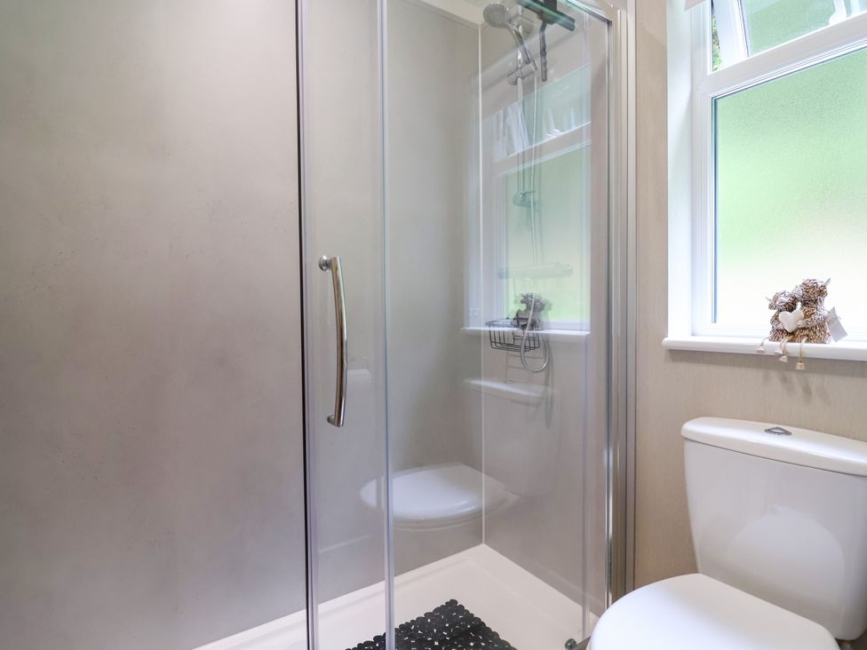 A bathroom featuring a shower and toilet at Beach Lodge in Lloc