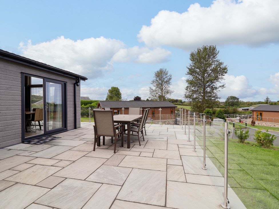 An outdoor dining area with a table and chairs at Beach Lodge in Lloc