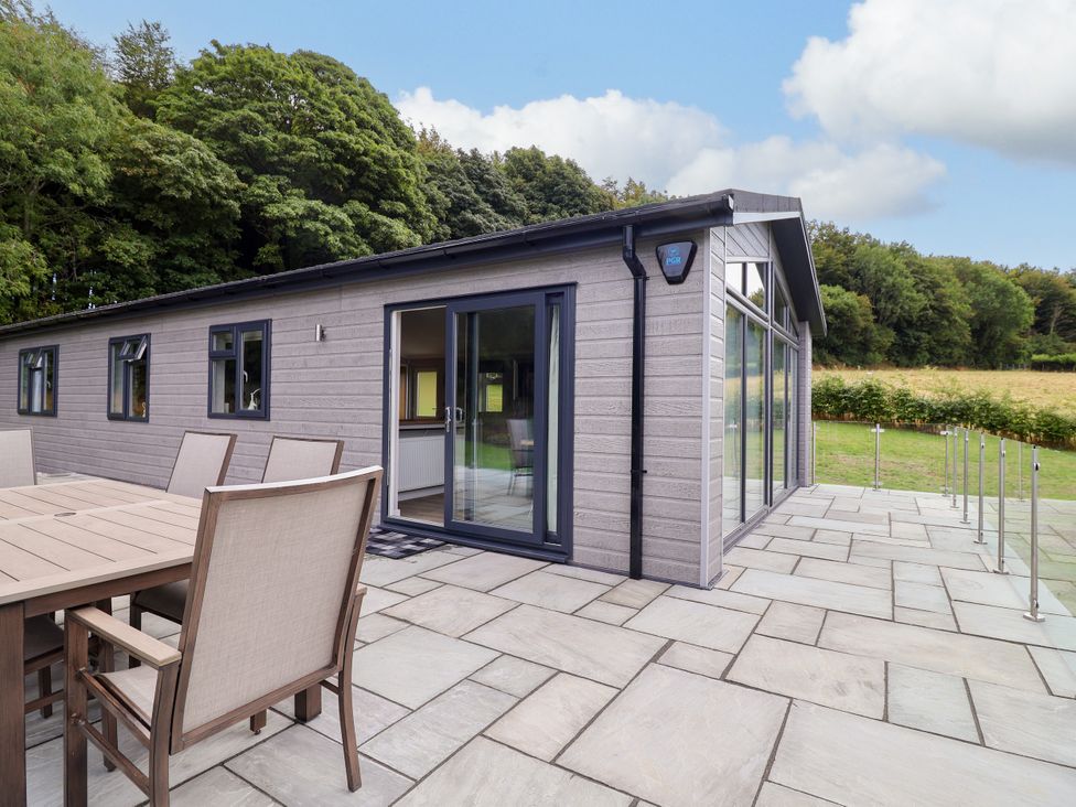A house with a patio area and outdoor furniture at Beach Lodge in Lloc