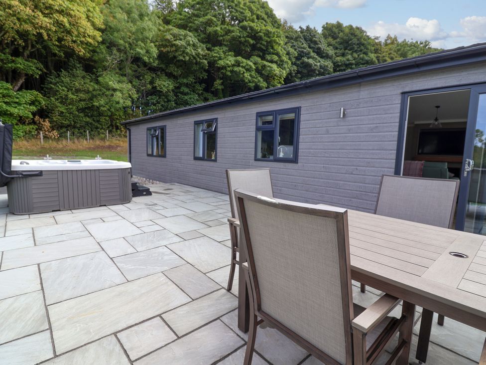 An outdoor space with a hot tub and dining furniture at Beach Lodge in Lloc