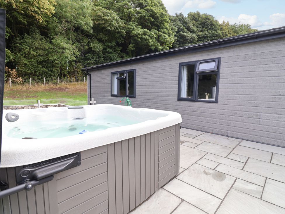 A hot tub near a building with a window at Beach Lodge in Lloc