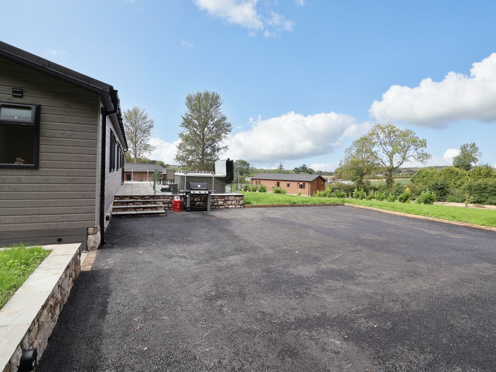 An outdoor area with a grill and parking space at Beach Lodge in Lloc