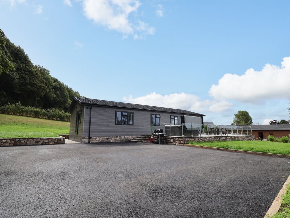 A house with a parking area and a lawn at Beach Lodge in Lloc