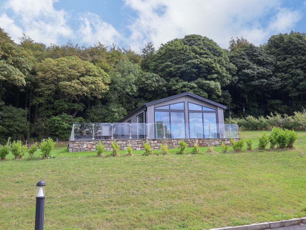 A building with glass features surrounded by trees at Beach Lodge in Lloc