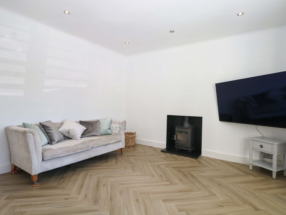A living room with a sofa and television at Shoreline Retreat in Bournemouth