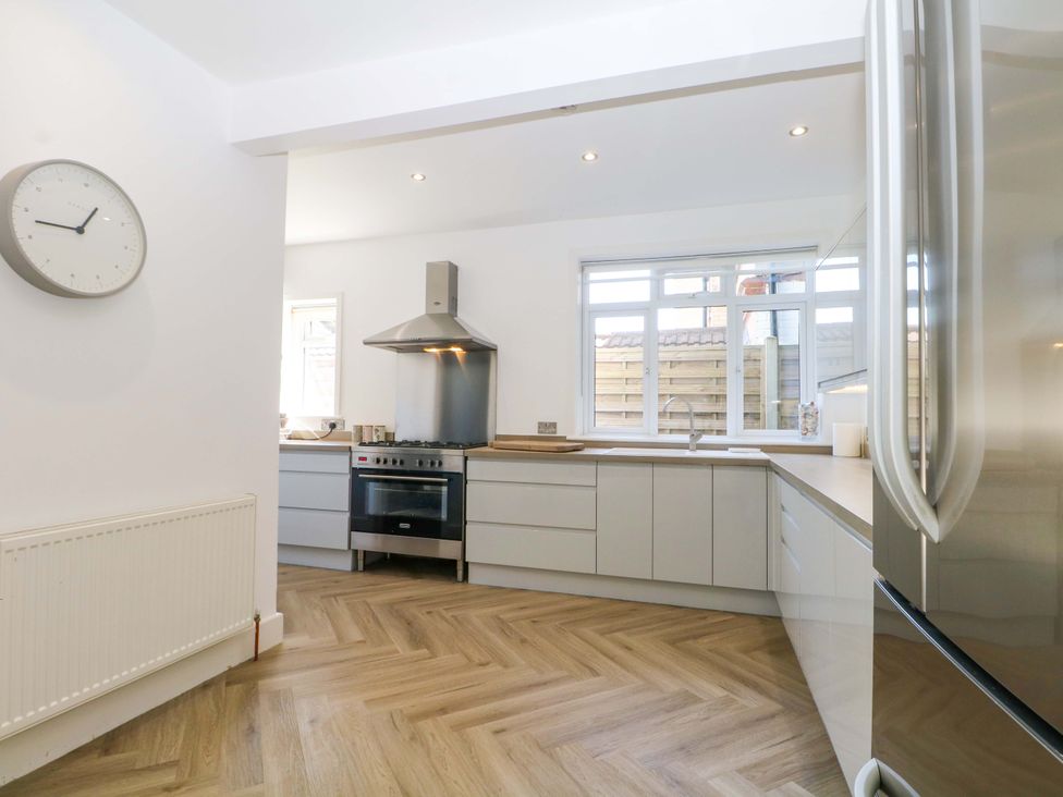 A kitchen with modern appliances and a clock at Shoreline Retreat in Bournemouth