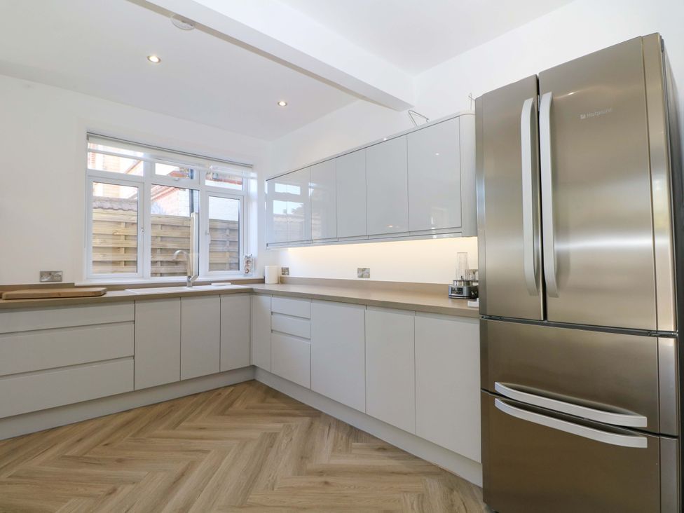 A kitchen with cabinets and a refrigerator at Shoreline Retreat in Bournemouth